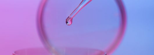 petri dish and dropping pipette with transparent liquid against gradient blue and purple background